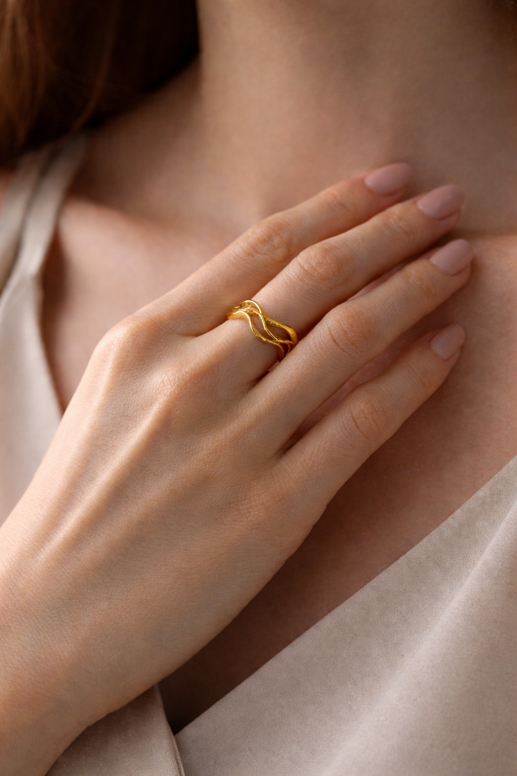 Gold Ripple Ring featuring a wavy, layered design on a jewelry display.