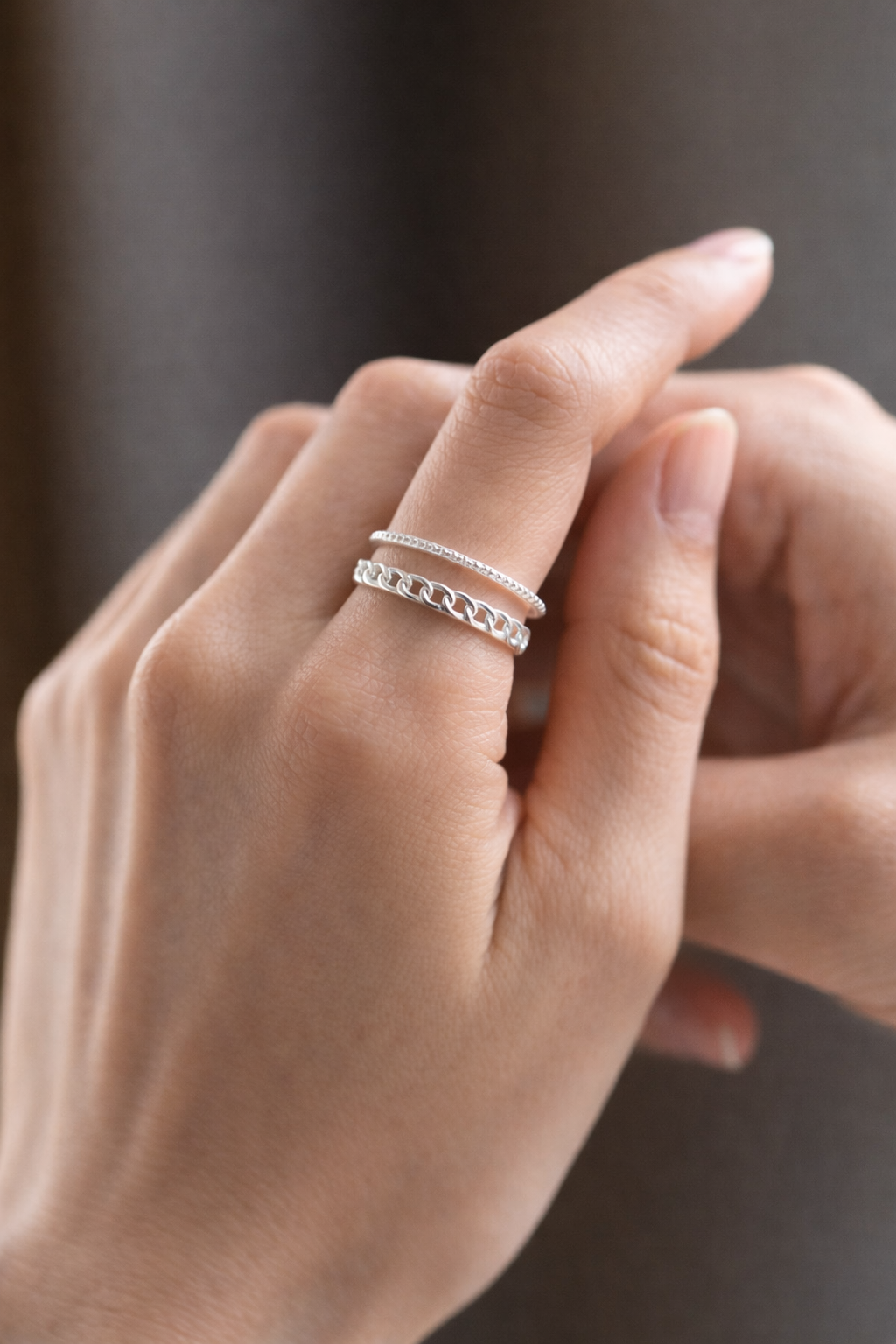 Tessa 3 Silver Tessa Ring with layered chain-link and beaded bands on a white stone.